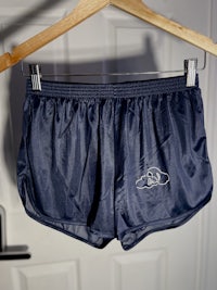 a pair of navy shorts hanging on a hanger